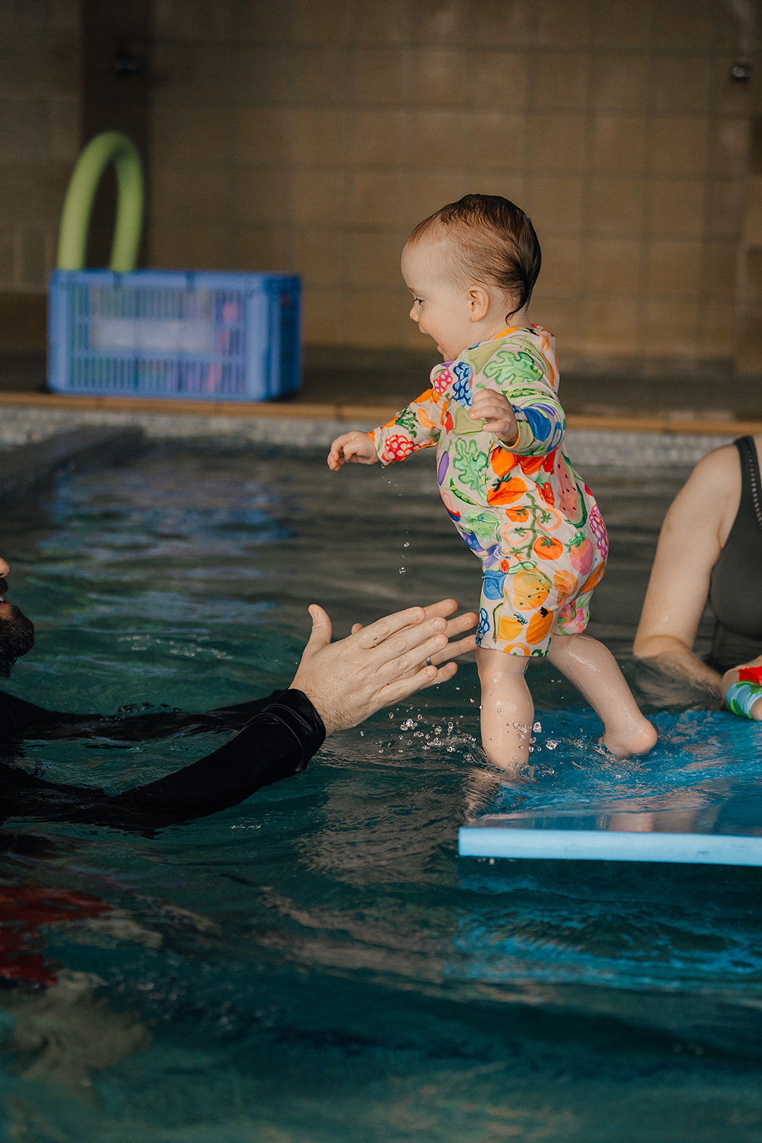 Baby reaching for pool toys at Tri Swimming