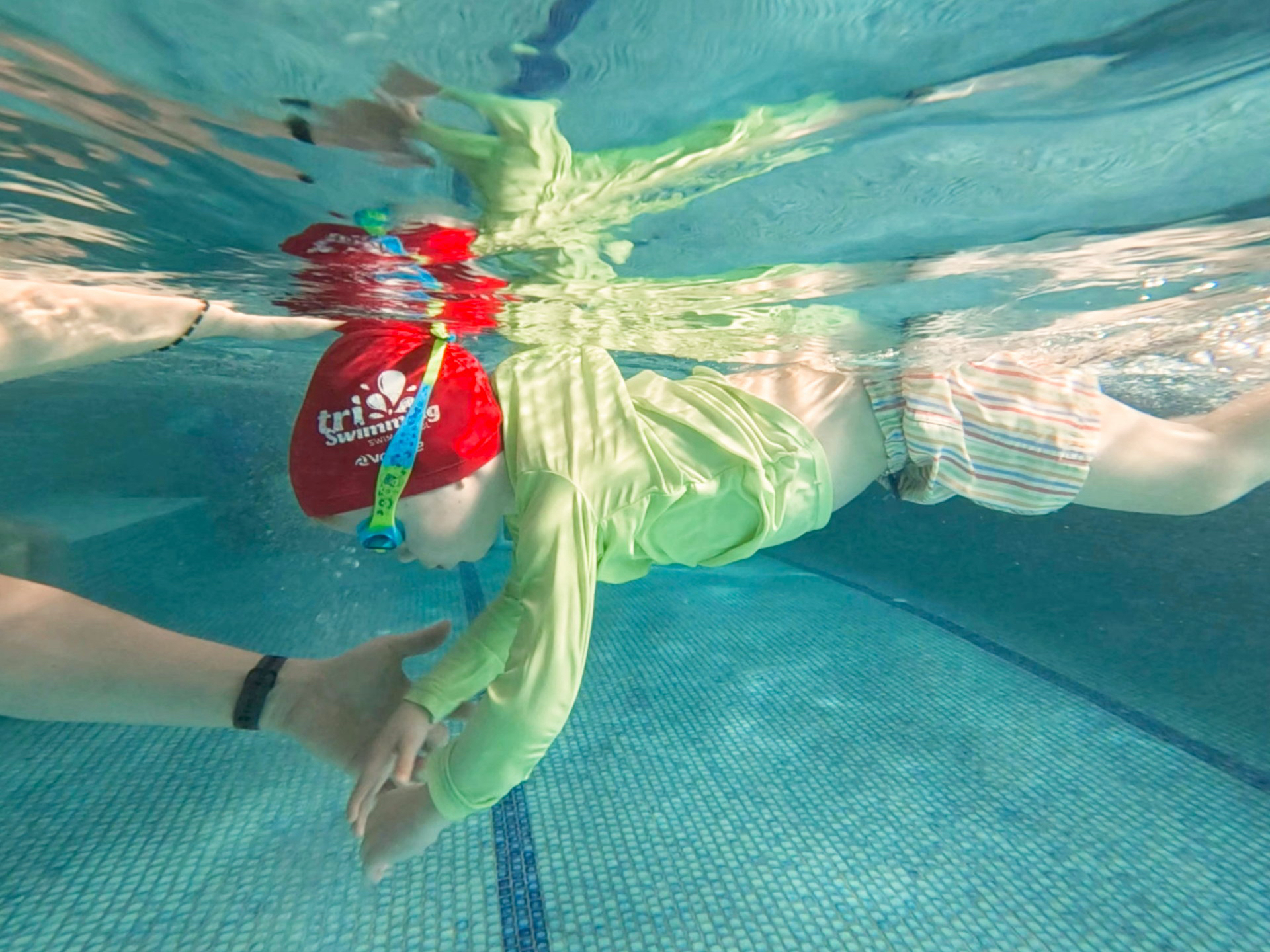 child and teacher with kickboard