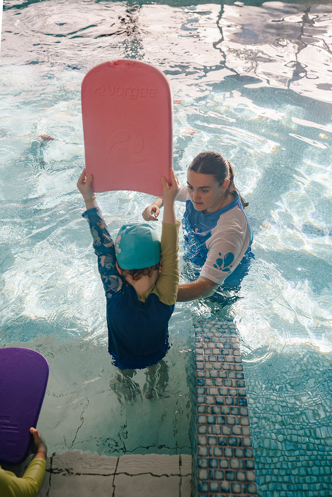 Baby reaching for pool toys at Tri Swimming